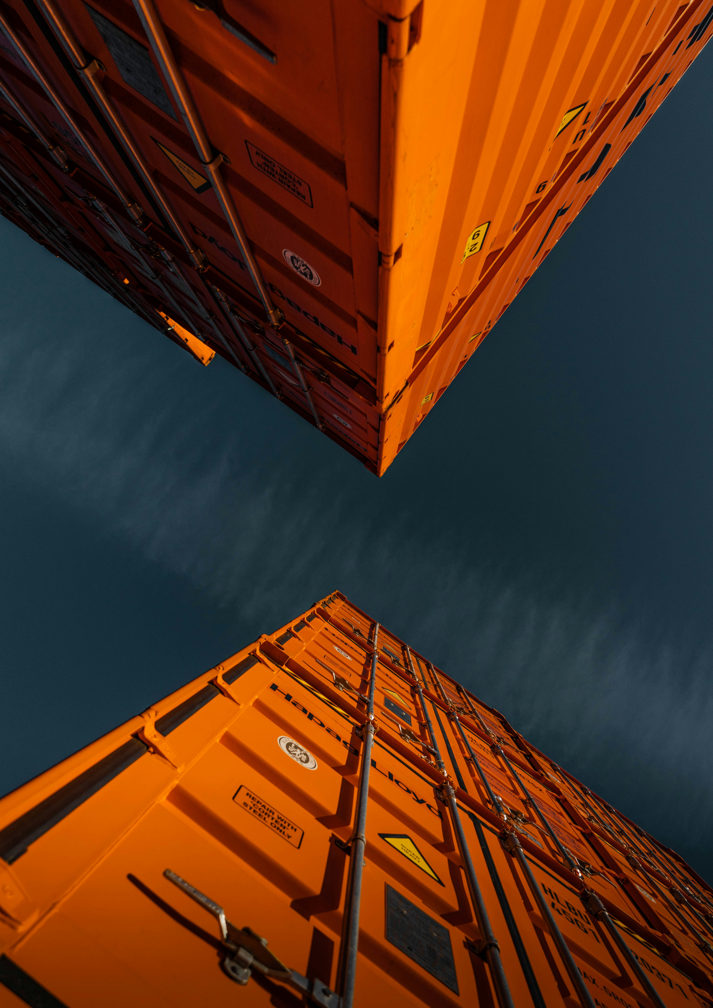 Shipping containers seen from below against a dark sky